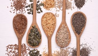 wooden spoons containing different nuts and seeds