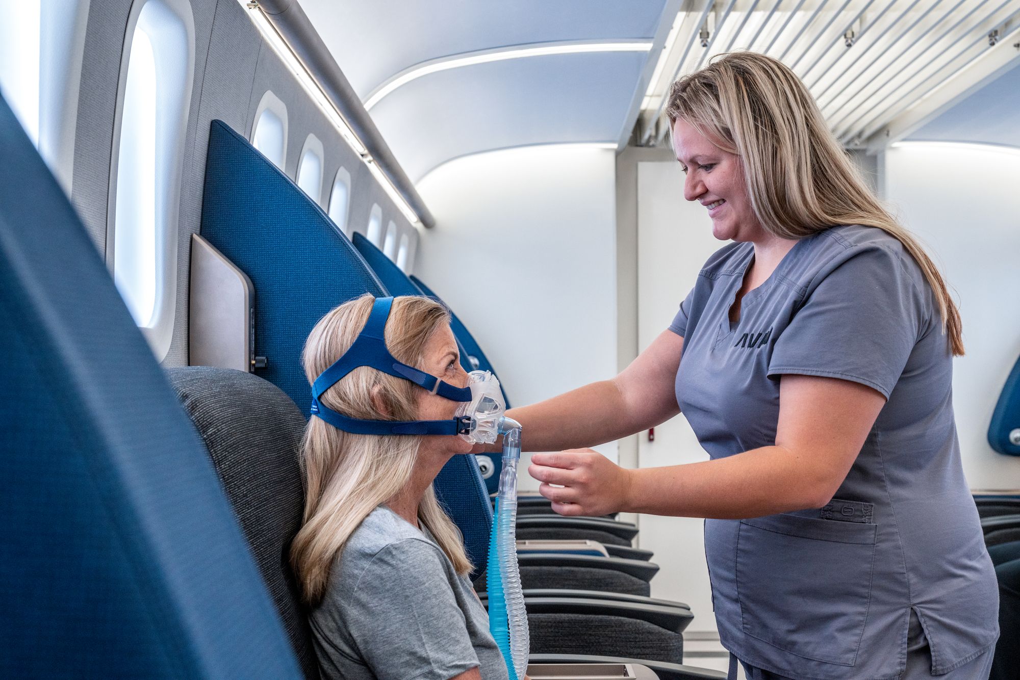 Nurse assisting woman with HBOT Mask