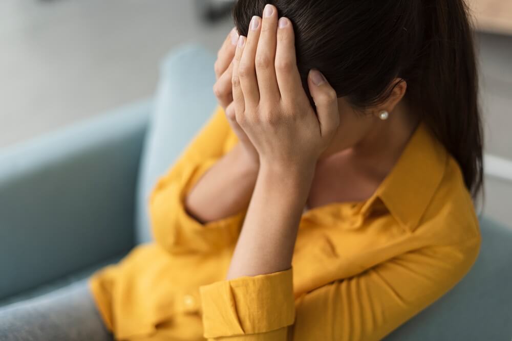 woman with head in hands and chronic pain