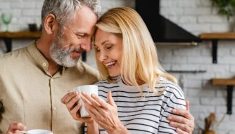 An older couple hugging and holding a cup