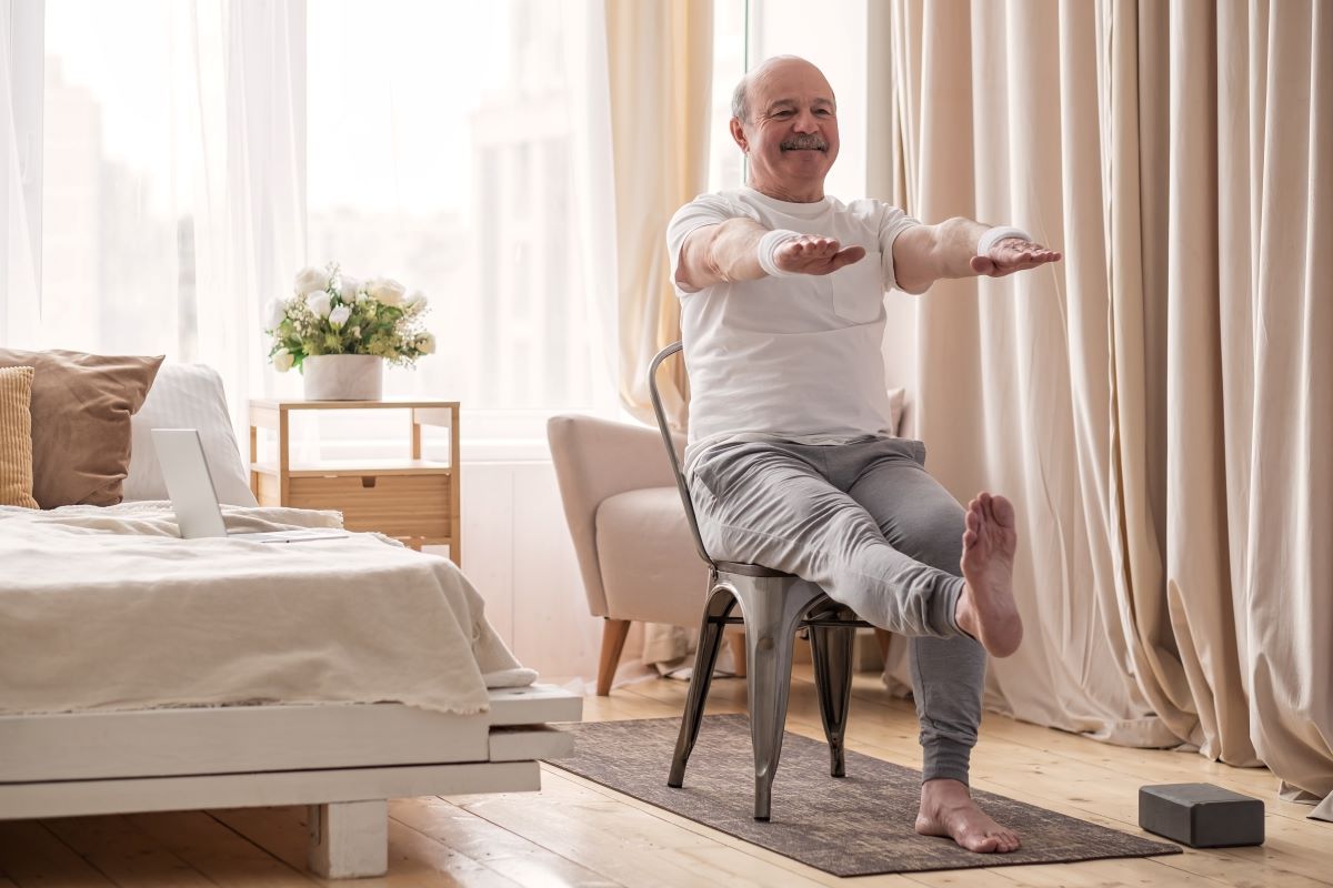 man doing balancing exercises in chair